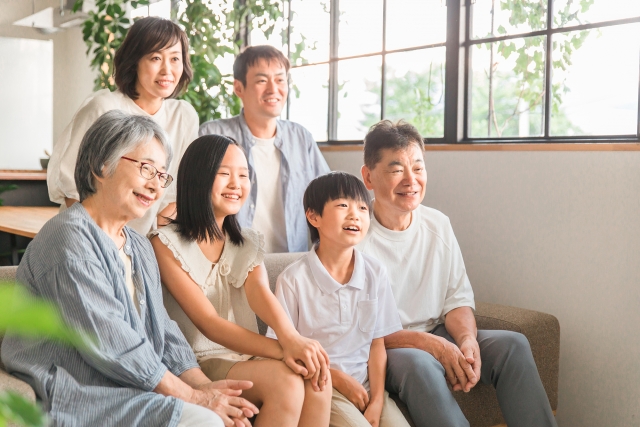 堺市の家族葬をイメージした、祖父母・親・子どもの三世代が和やかに団欒している様子の写真。